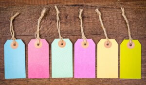 Set of colorful blank hang tag on wooden background.