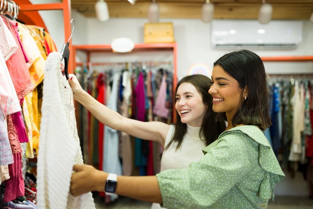 two women looking at clothing in thrift store