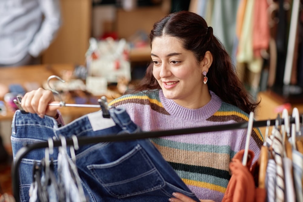 woman looking at clothes in thrift store